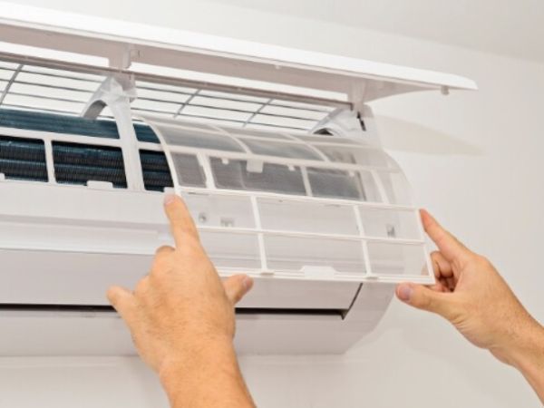 Man checking the air filter of AC.